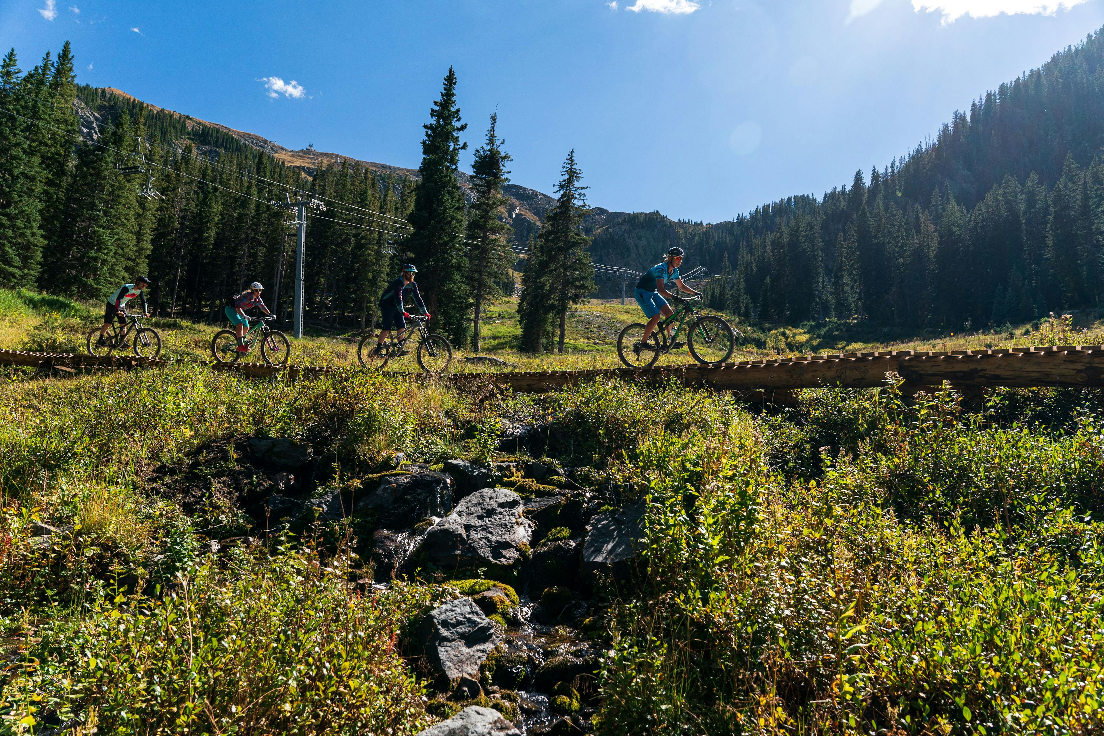 Four bikers on a bike park trail at Taos Ski Valley