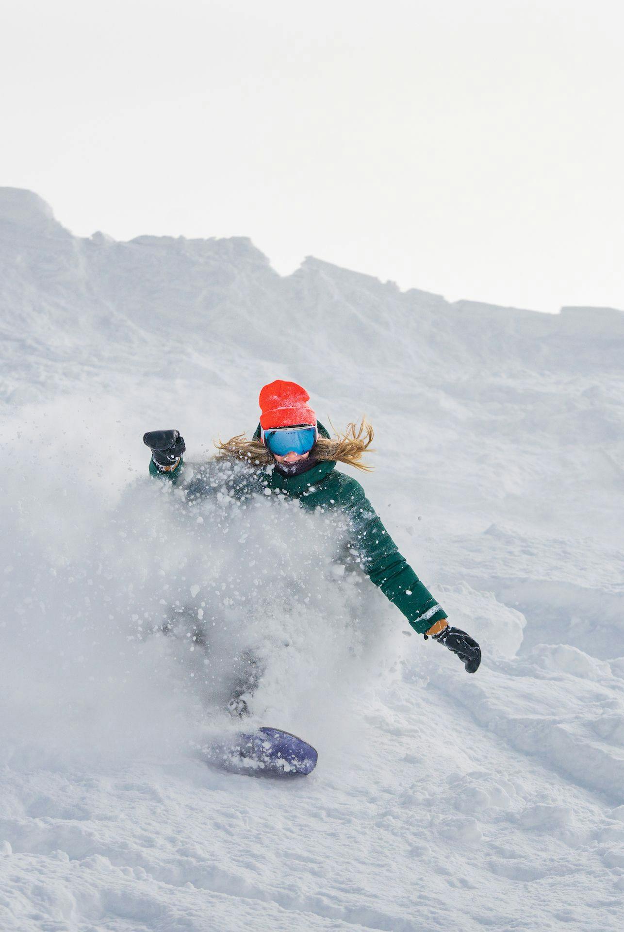 Snowboarder rides down steep terrain at Taos Ski Valley