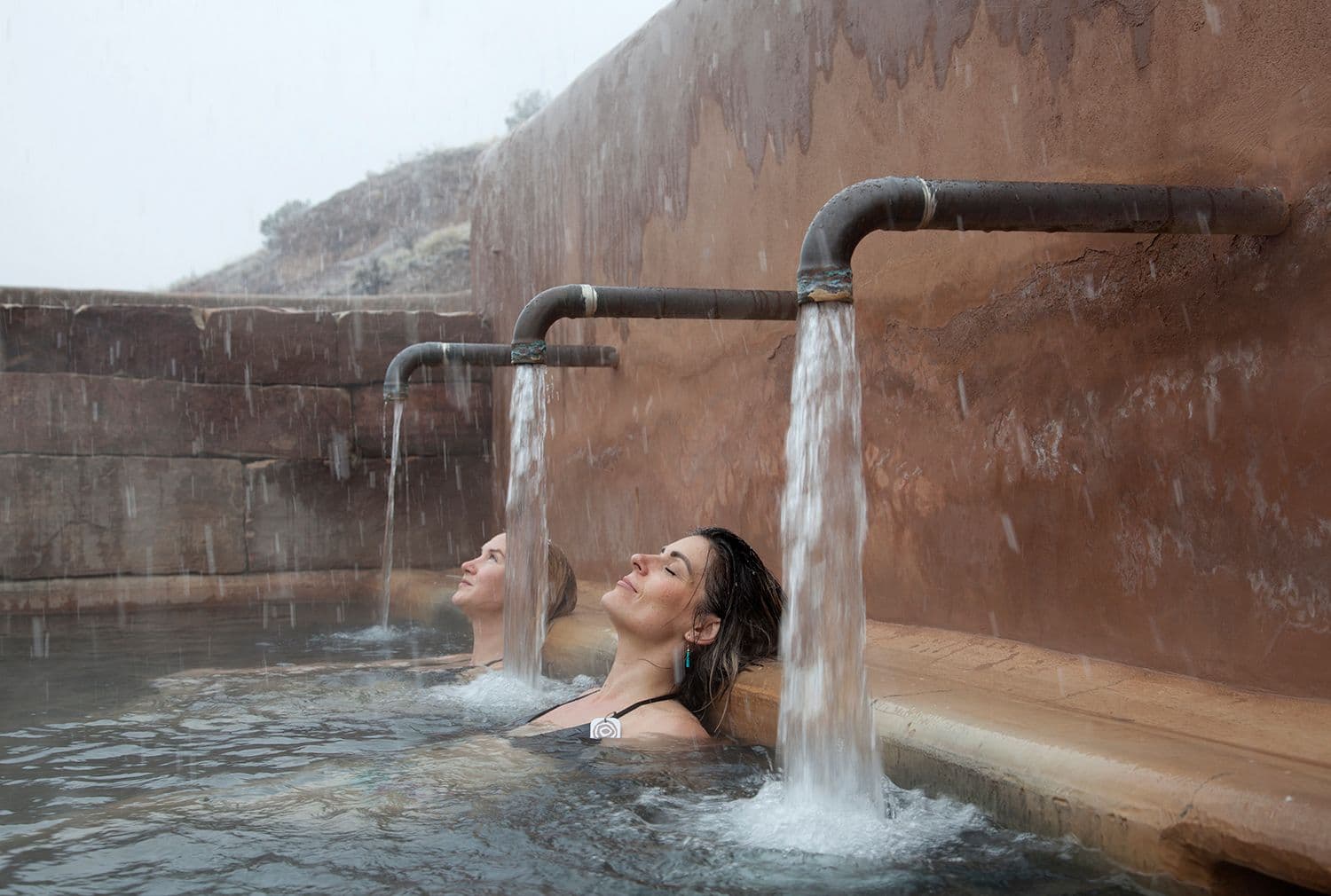 Two people sit in a soaking pool at Ojo Caliente in New Mexico.