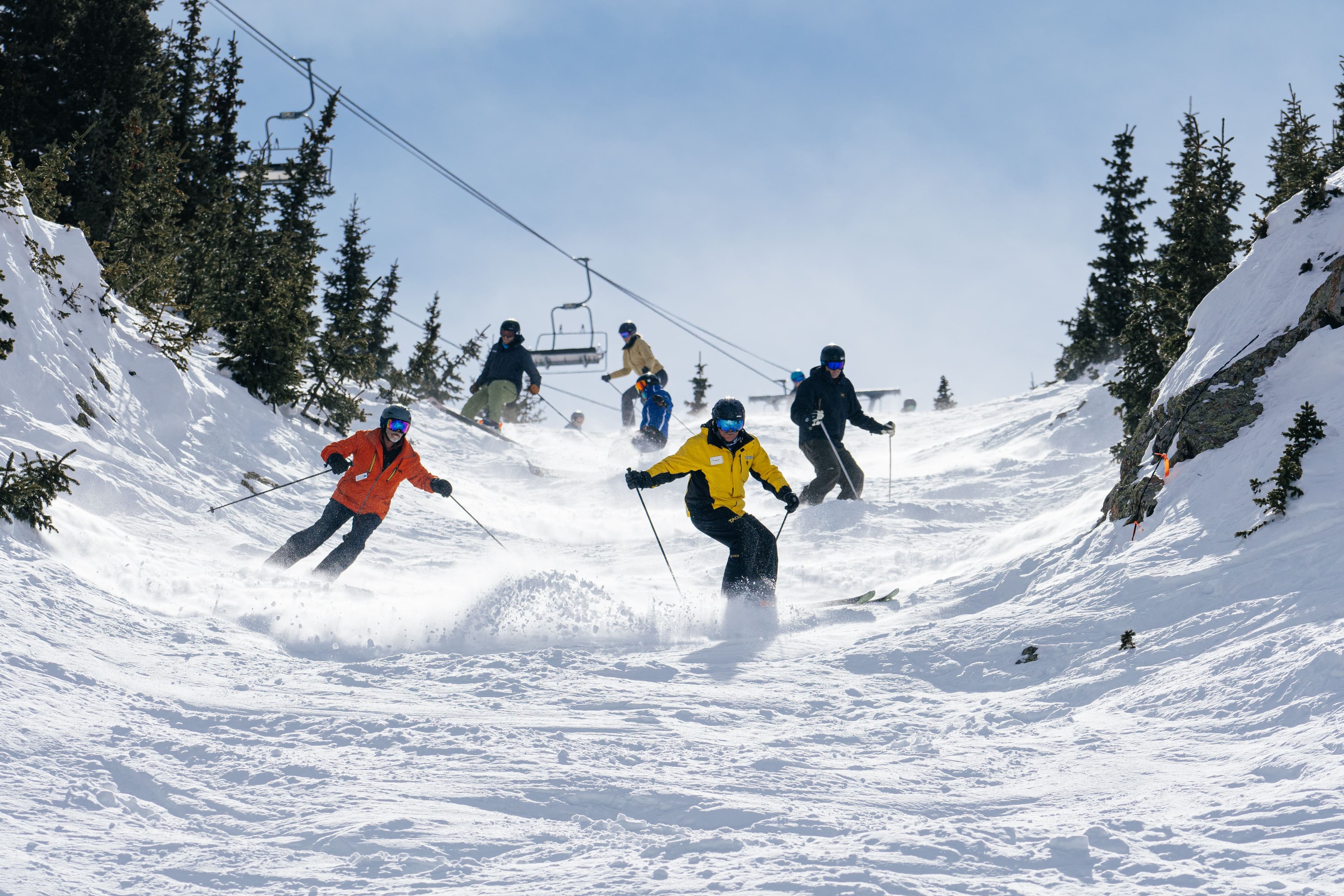 Ski instructor leads a group down a mogul run at Taos Ski Valley.