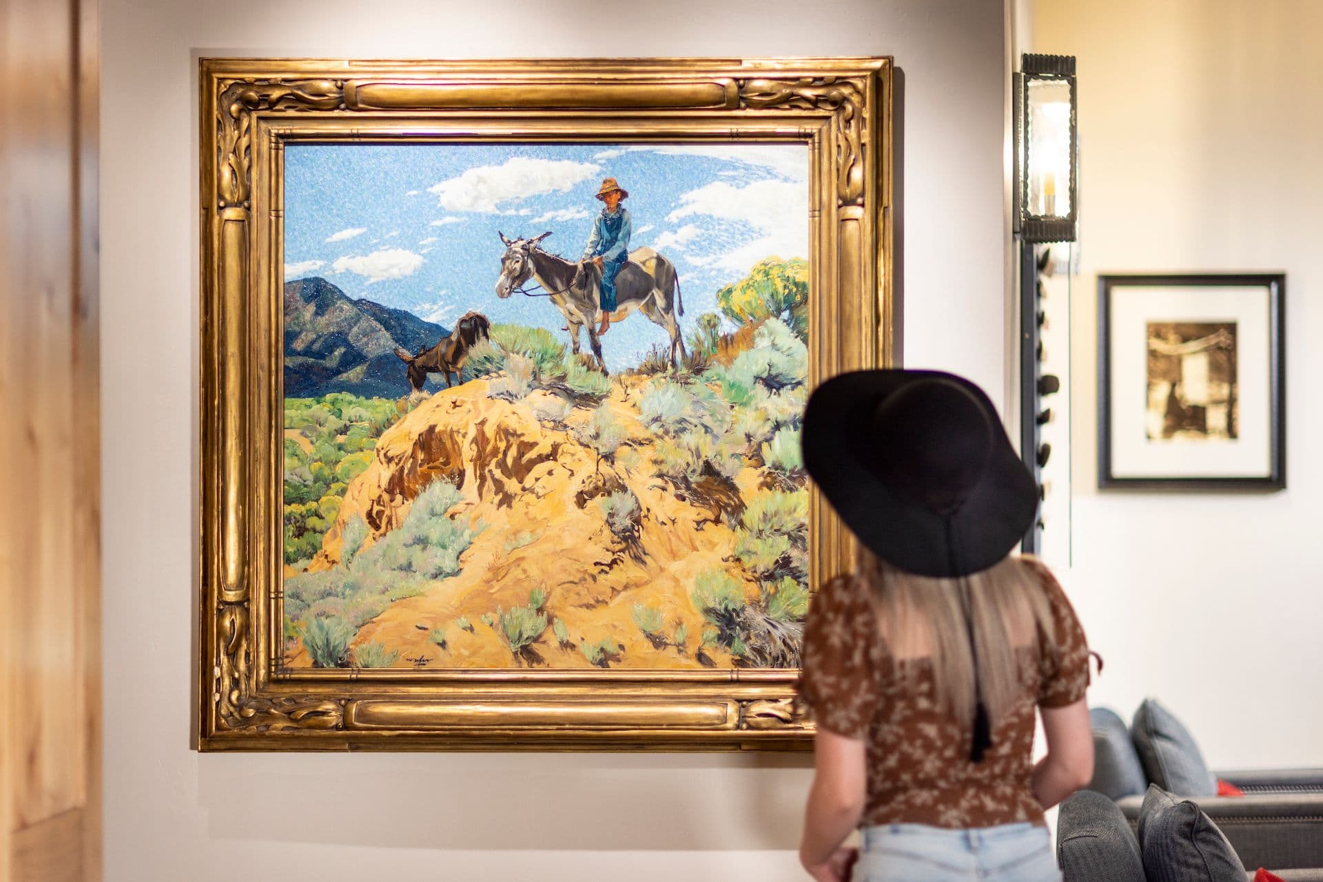 A woman looks at a Walter Ufer painting in the lobby of The Blake.